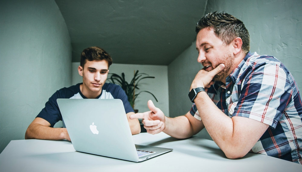 Manager mentoring employee at a desk
