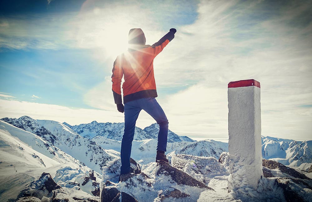 rock climber celebrates on reaching the mountain's summit.