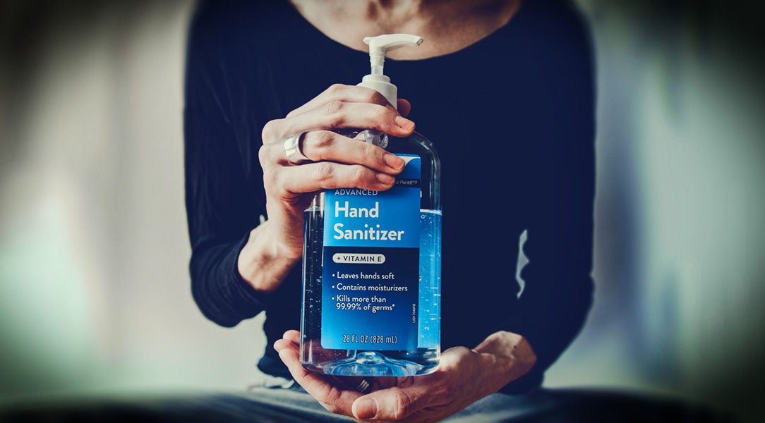 Close up of person holding a big bottle of hand sanitiser