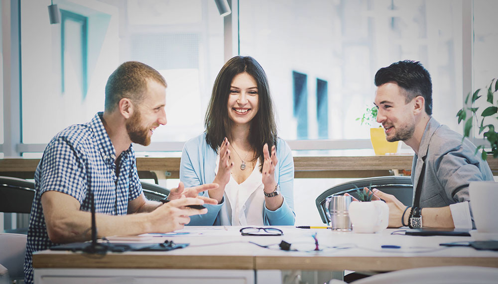 work collegues laugh togehter at desk